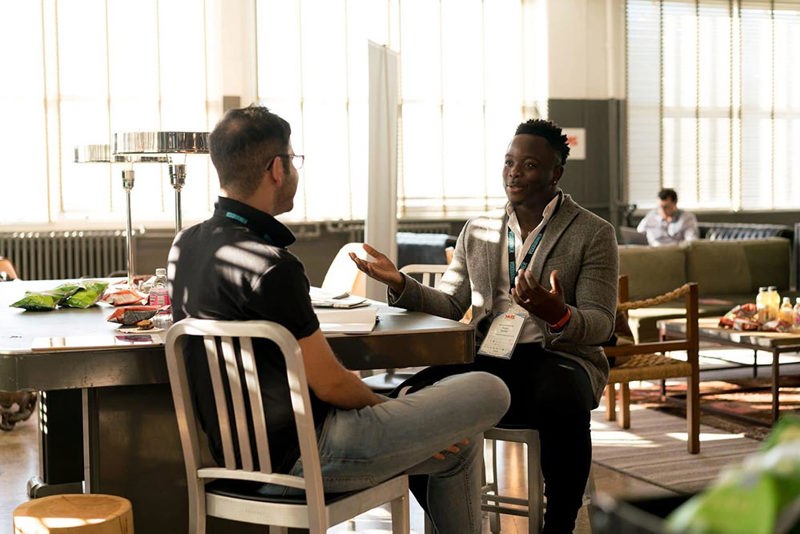 two men sitting and talking in a casual setting