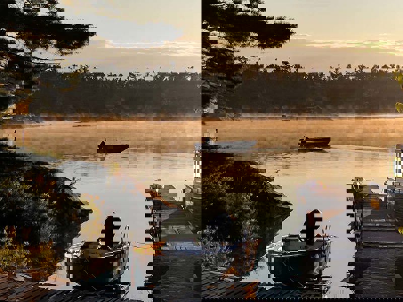 Sunrise over a lake and a fisherman returning to the dock